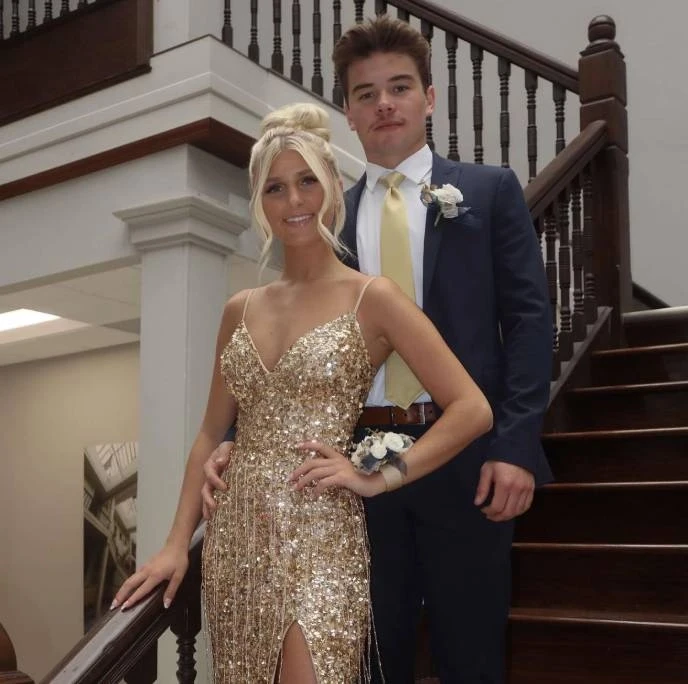 Сouple wearing a golden gown and a blue suit